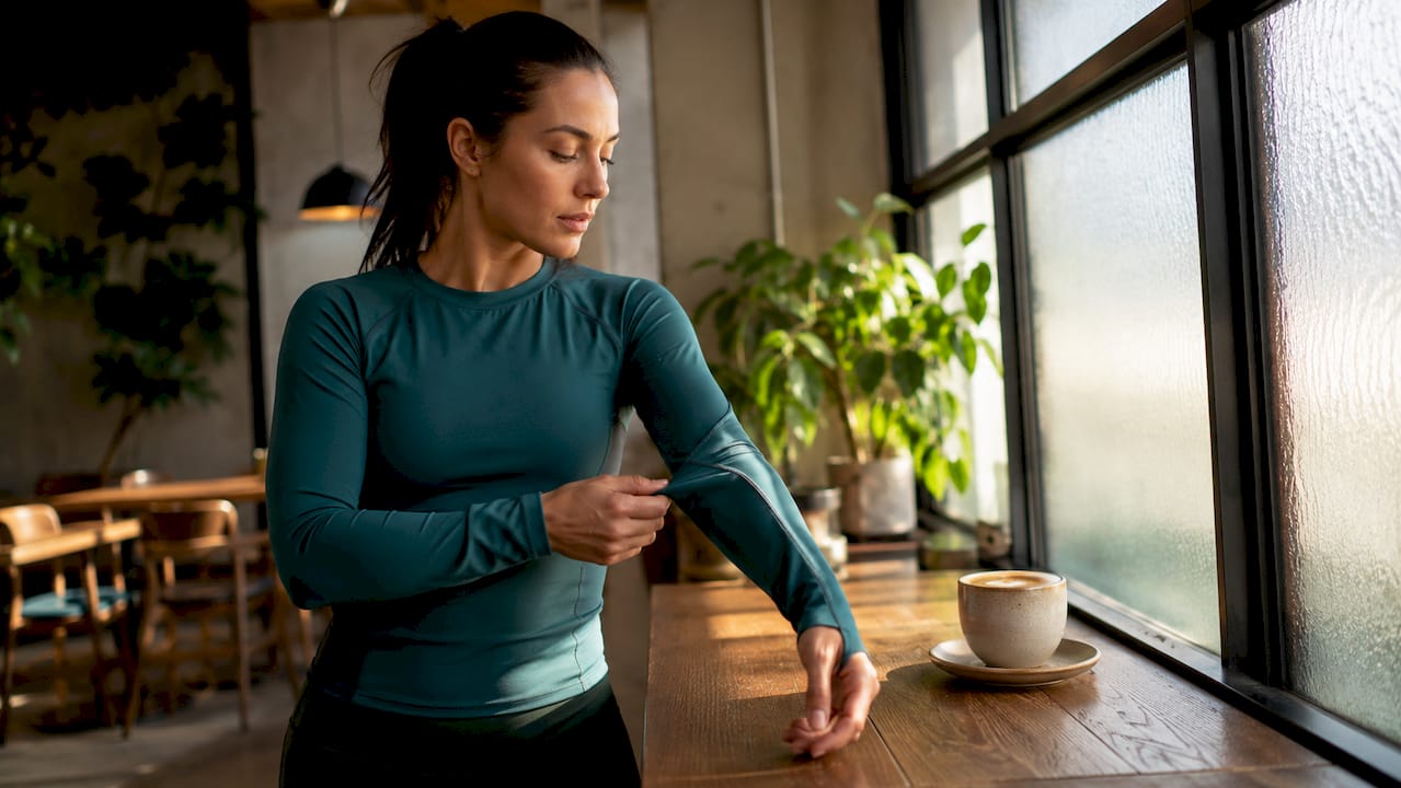 Athlete examining workout clothes fabric in gym